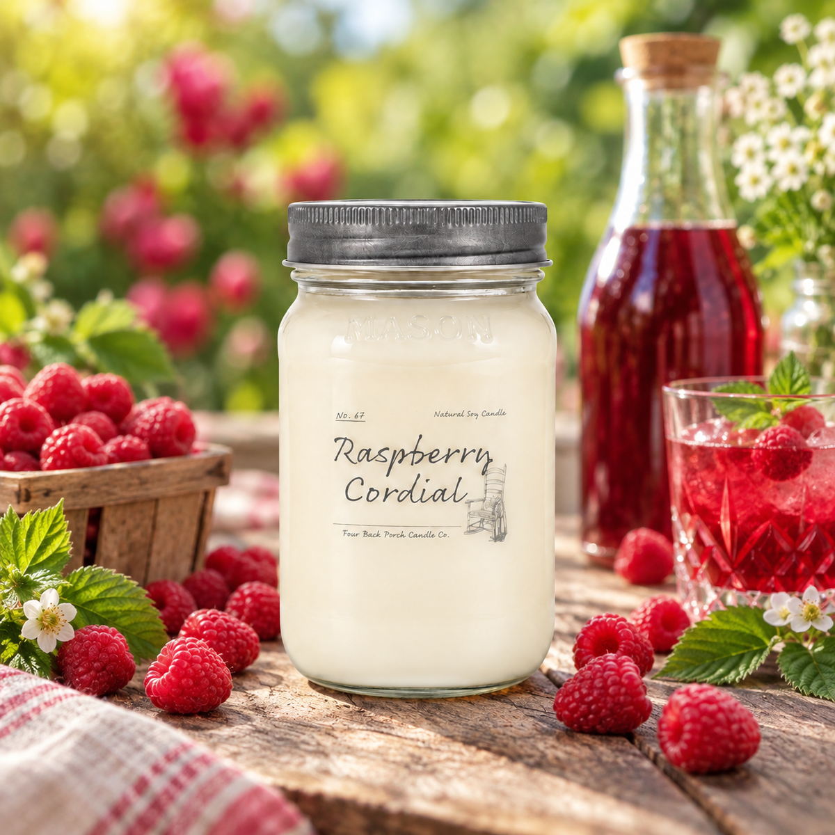 Back Porch Candle Co Raspberry Cordial 16 oz soy candle styled with raspberries and raspberry cordial in a bright rustic setting.