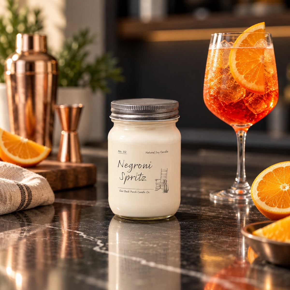 Negroni Spritz 8 oz soy candle by Back Porch Candle Co. styled with citrus and an elegant spritz cocktail scene.