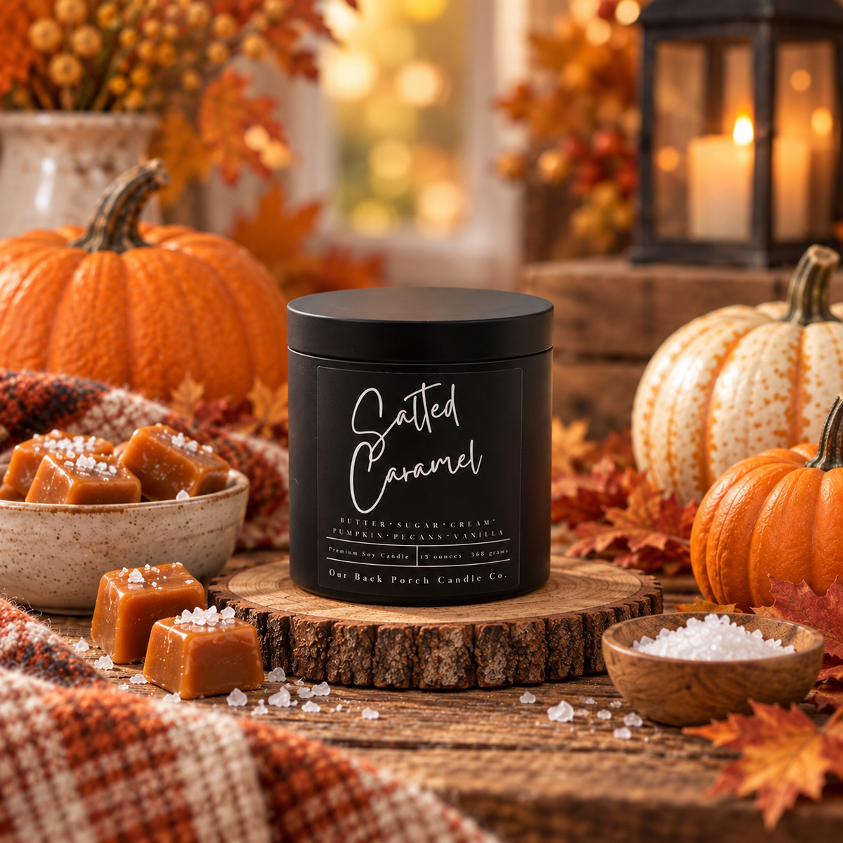 Salted Caramel matte black soy candle by Back Porch Candle Co. styled with pumpkins, salted caramel candies, autumn leaves and warm lantern light.