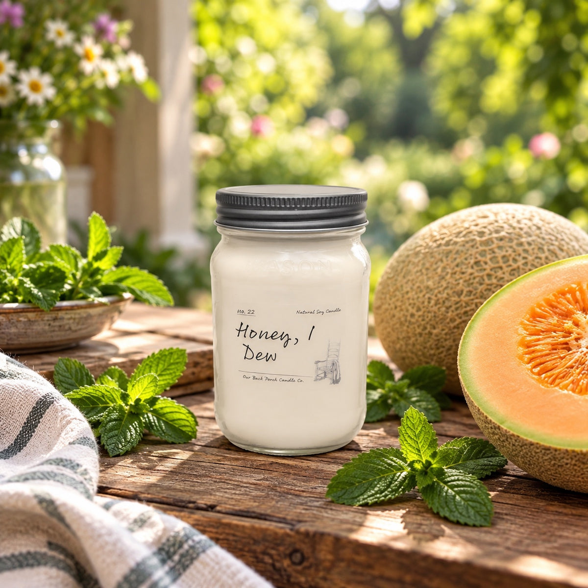 Honey, I Dew 16 oz soy candle by Back Porch Candle Co. styled with melon, mint, and warm summer light.